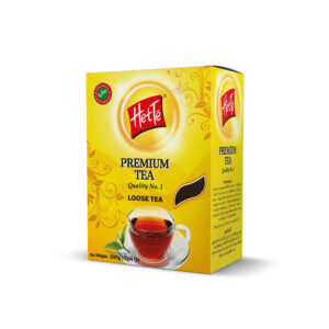Yellow Heté Premium Tea box featuring a red logo and a teacup illustration on the front