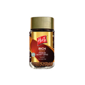 Jar of Heté Rich Brew Premium Instant Coffee with a gold lid and ornate brown–gold label, glass container showing coffee granules at the bottom.